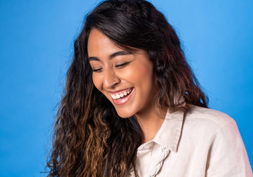 Jovem sorrindo no escritório da Bluy